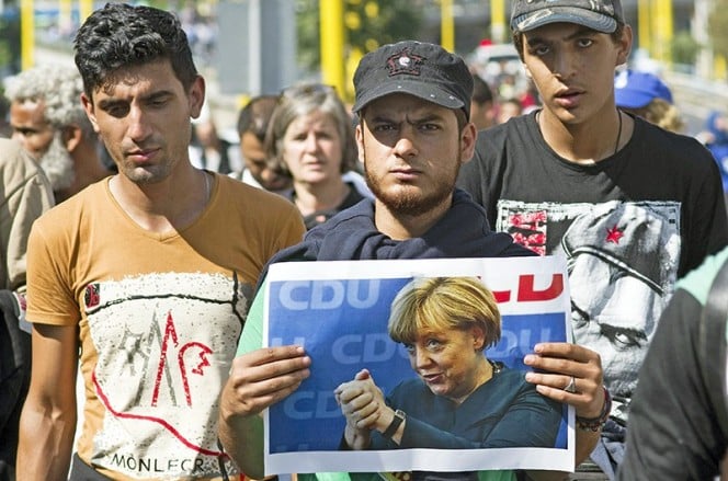 Migrants with the photo of the Chancellor of German Angela Merkel