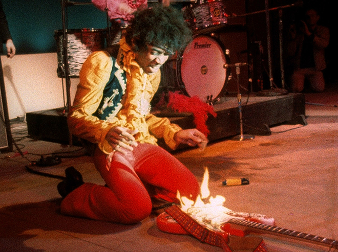 Jimi Hendrix is burning a guitar