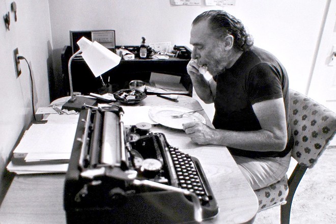Charles Bukowski behind his desk