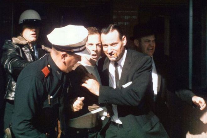 The police is leading Lee Harvey Oswald from the Texas Theater