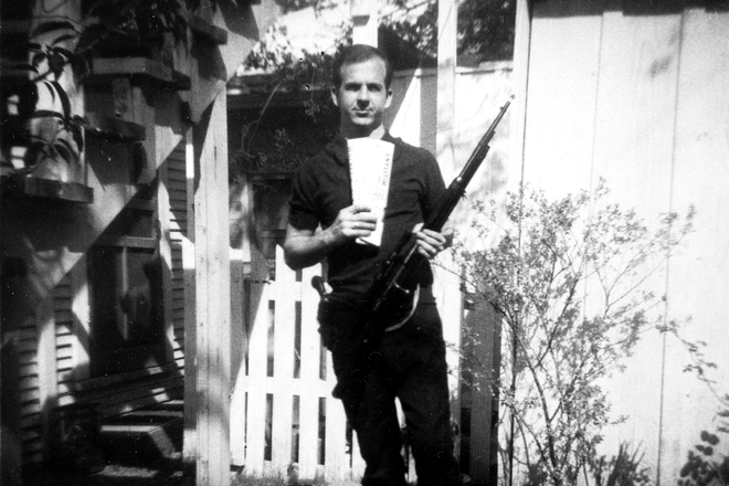 Lee Harvey Oswald posing with a Carcano rifle and Marxist newspapers
