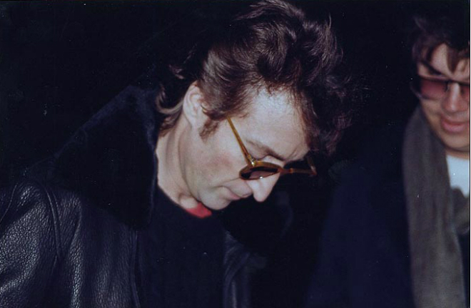 John Lennon signs a copy of Double Fantasy album for Mark Chapman (seen on the right)