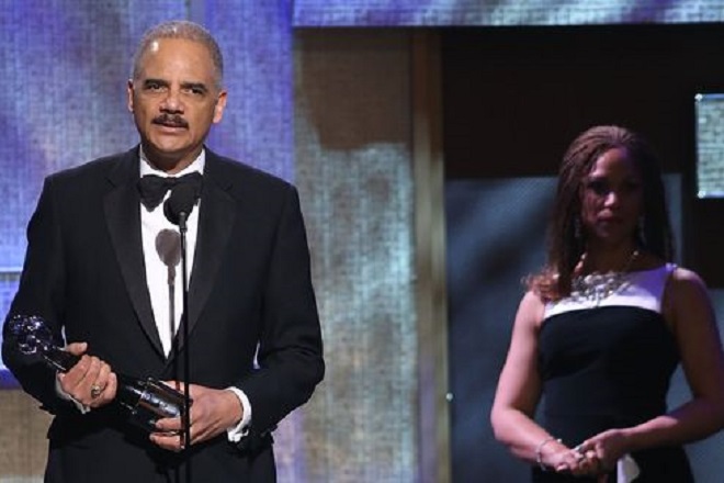 Eric Holder speaks on stage after receiving an award