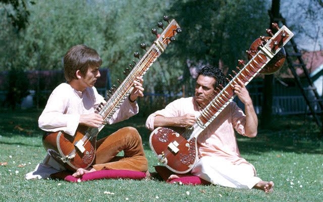 George Harrison and Ravi Shankar are playing the sitars