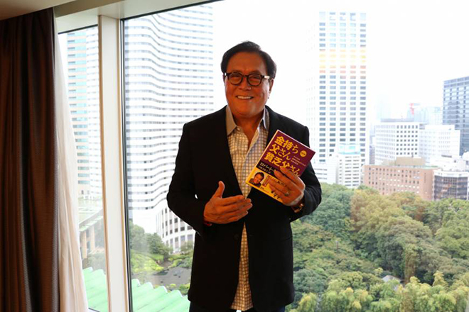 Robert Kiyosaki with a book